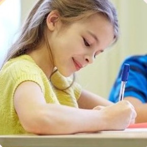 Meisje schrijft geconcentreerd in een schrift in de klas